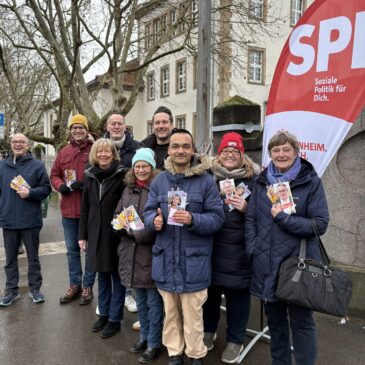 Mitglieder SPD Gonsenheim mit Doris Ahnen, Michael Ebling und Daniel Stich stehen an einem Infostand. Alle halten Flyer mit Alexander Schweitzer in der Hand.